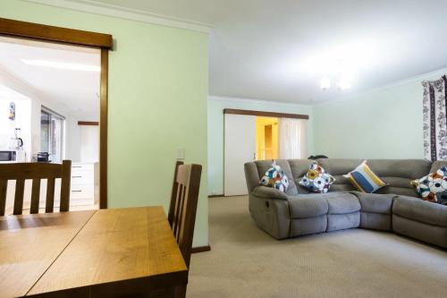 a living room with a couch and a table at Well equipped 3BR Home with Backyard and Patio in Perth
