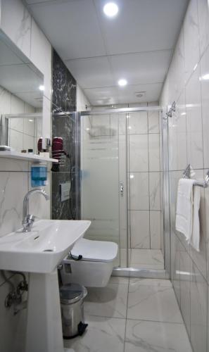a bathroom with a shower and a sink and a toilet at Hill Life Hotel in Lüleburgaz