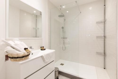 une salle de bain blanche avec une douche et un lavabo dans l'établissement L'Ammarage YourHostHelper, à Grimaud