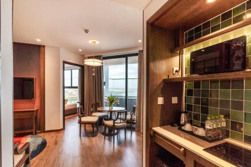 a kitchen and living room with a table and chairs at Apec Mandala Harmony Resort & Spa in Mui Ne