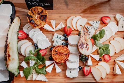 a bunch of cheese and fruit on a cutting board at Hotel Marina Club in Olsztyn