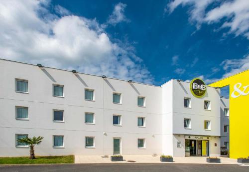 a white building with a sysco sign on it at B&B HOTEL Vannes Ouest Golfe du Morbihan in Vannes
