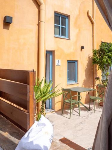 a patio with a table and chairs and a building at Casa del Sol Suites in Rhodes Town