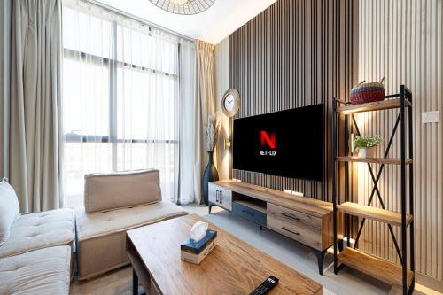 a living room with a tv and a couch at 1BR The Sandstone Apartment by Blue Cloud Holidays in Sharjah Intl