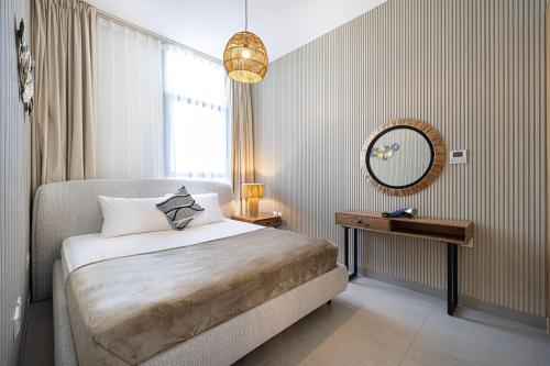 a bedroom with a bed and a mirror and a window at 1BR The Sandstone Apartment by Blue Cloud Holidays in Sharjah Intl