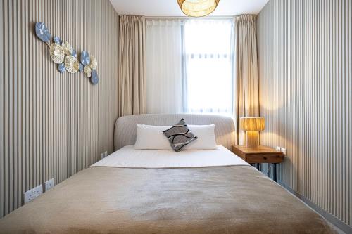 a bedroom with a large bed with a window and a bed sidx sidx at 1BR The Sandstone Apartment by Blue Cloud Holidays in Sharjah Intl