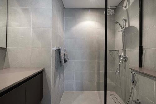 a shower with a glass door in a bathroom at 1BR The Modern Al Jada Home by Blue Cloud Holidays in Sharjah