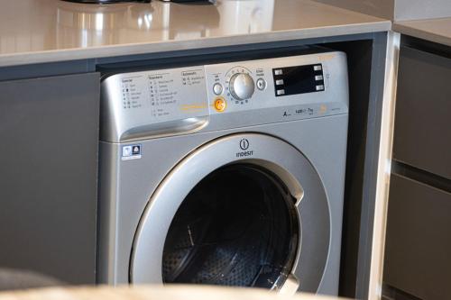 a washing machine in a kitchen next to a counter at 1BR The Modern Al Jada Home by Blue Cloud Holidays in Sharjah