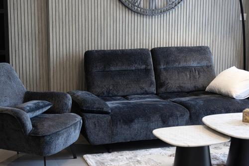 a living room with a couch and two chairs at 1BR The Modern Al Jada Home by Blue Cloud Holidays in Sharjah