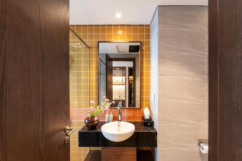 a bathroom with a sink and a mirror at Apec Mandala Harmony Resort & Spa in Mui Ne