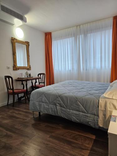 a bedroom with a bed and a table with chairs at Victoria Royal Garden in Como