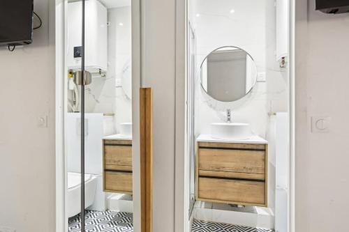 une salle de bain avec un lavabo et un miroir dans l'établissement Studio Arc de Triomphe, à Paris
