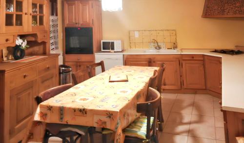 une cuisine avec une table recouverte d'une nappe dans l'établissement Maison de charme avec vue sur la montagne à Albaret-Sainte-Marie, à Albaret-Sainte-Marie