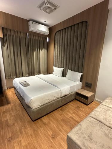 a bedroom with a large bed and a large window at Hotel victoria prime in Surat