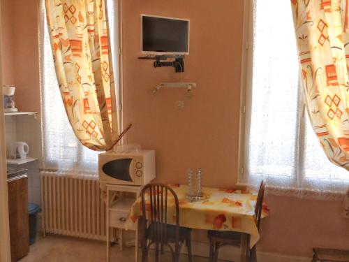 une petite salle à manger avec une table et une télévision dans l'établissement Studio confort à Néris-les-Bains - 18 m² avec jardin, à Néris-les-Bains