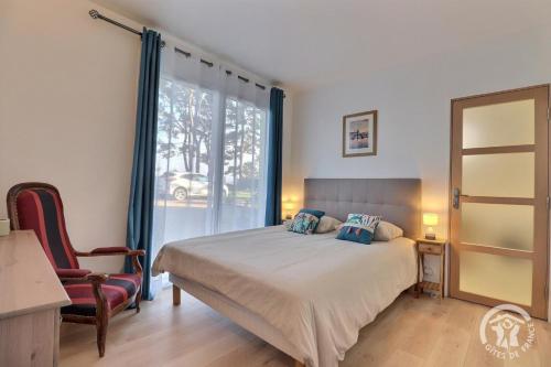 une chambre avec un lit, une chaise et une fenêtre dans l'établissement Ty gwenn, à Cancale