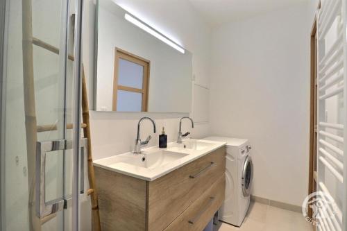 une salle de bain avec un lavabo et un miroir dans l'établissement Ty gwenn, à Cancale