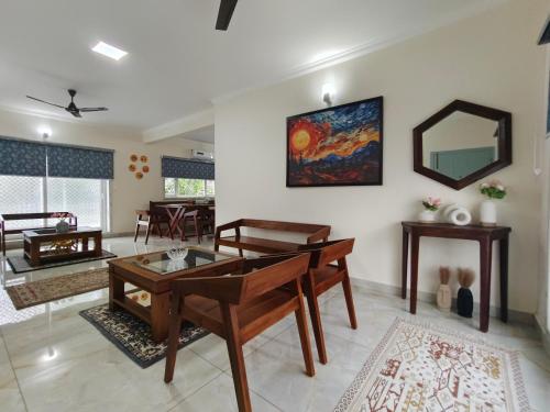 a living room with a table and a mirror at Best 2x3BHK Premium Homestay - Emerald, 7 Elysee Homestay in Trichūr