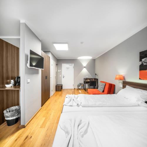 a bedroom with a bed and a tv on a wall at BoardingWorld Heidelberg in Heidelberg