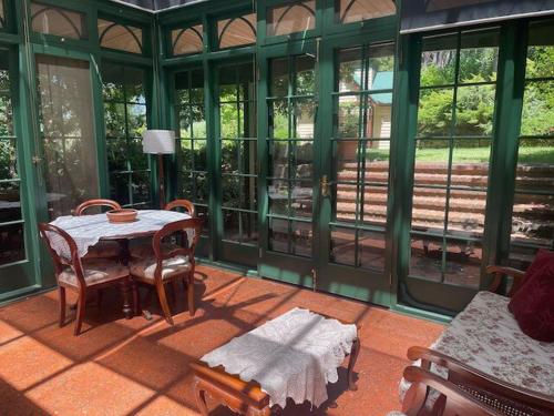 a screened in porch with a table and chairs at The Garden Gatehouse in Aldgate