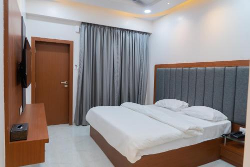 a bedroom with a large bed and a window at Aarya Inn in Srīvardhan