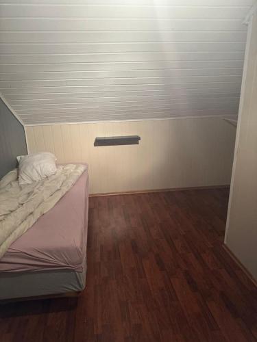 a small room with a bed and a wooden floor at Hus i Olderfjord in Lyngværet