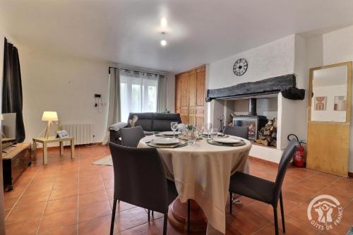 un salon avec une table et une cheminée dans l'établissement La ville lesne 2, à Montauban-de-Bretagne