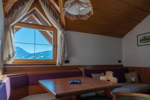 a living room with a table and a window at Smy Koflerhof Wellness & Spa Dolomiti in Rasun di Sopra