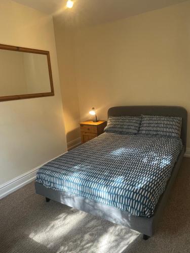 a small bedroom with a bed and a mirror at Mayfield House in Hull