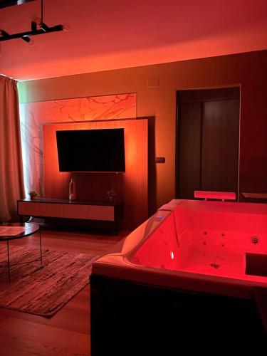 a living room with a red bath tub and a television at Jacuzzi Old Town Escape in Bucharest