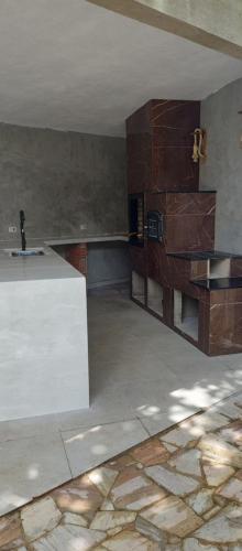 Ein leerer Raum mit einer weißen Theke und Holzwänden in der Unterkunft Paradise nook house in Itanhaém