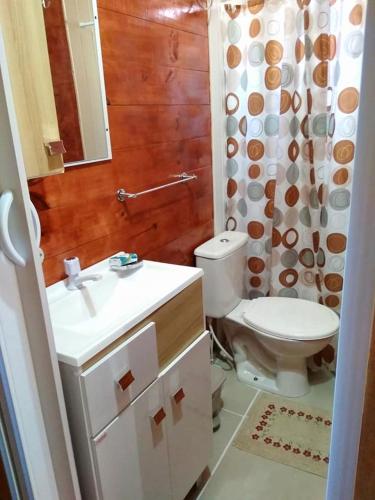 a bathroom with a toilet and a sink and a mirror at Cabañas Recanto do pepe in Santa Vitória do Palmar