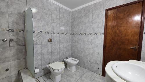 a bathroom with a toilet and a sink at Tajy Iguazu Hotel in Puerto Iguazú