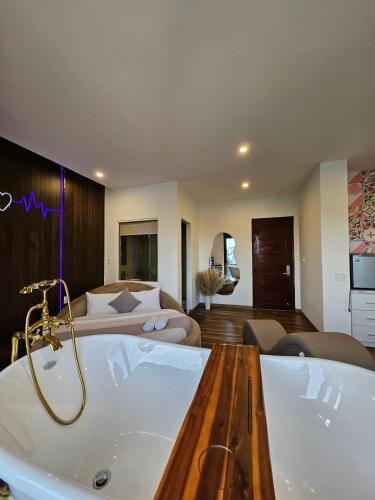 a large bathroom with a tub and a bed at Ngàn Phố Studio & Love Hotel in Da Lat