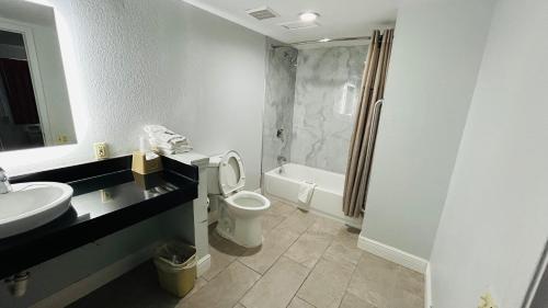 a bathroom with a sink and a toilet and a shower at Super 7 Inn Tupelo in Tupelo
