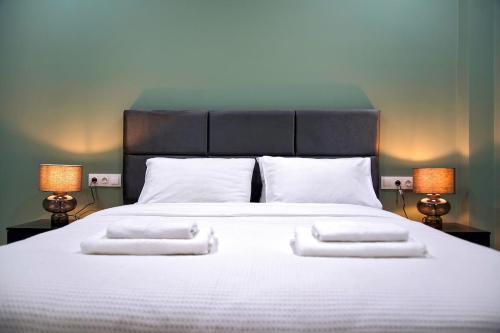 a large white bed with two pillows and two lamps at Aegean Modern Escape VIPGreece in Piraeus
