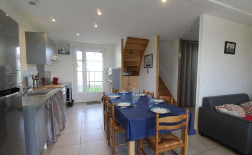 une cuisine et un salon avec une table et un chiffon bleu dans l'établissement La Croix du Sud, à Saint-Xandre