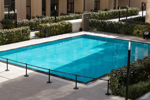 a large blue swimming pool next to a building at 1BR The Sandstone Apartment by Blue Cloud Holidays in Sharjah Intl