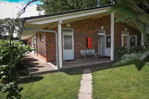 a brick house with a bench on a porch at Sleep Space 3 - Green Tiny Spot Friesland in Schortens