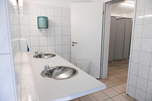 a bathroom with two sinks in a public restroom at Sleep Space 3 - Green Tiny Spot Friesland in Schortens