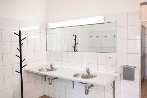 a bathroom with two sinks and a mirror at Sleep Space 3 - Green Tiny Spot Friesland in Schortens