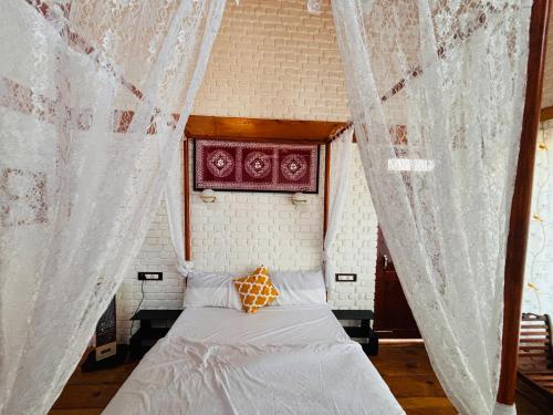 a bed in a room with a curtain at Panchwati Farms Homestay in Almora