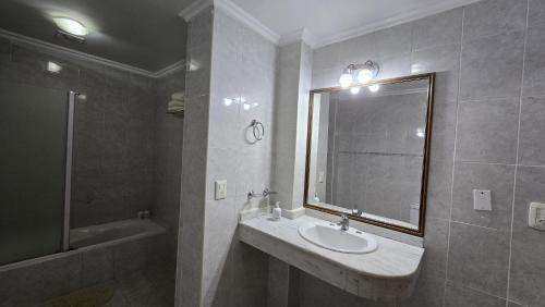 a bathroom with a sink and a window and a tub at Tajy Iguazu Hotel in Puerto Iguazú