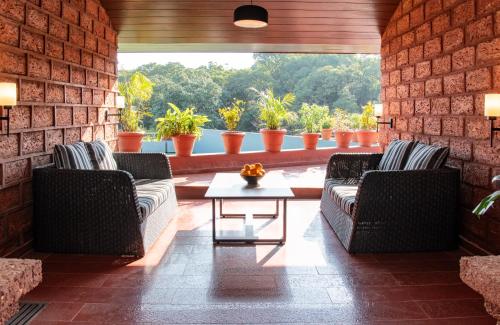 a living room with two couches and a table at Brightland Resort & Spa in Mahabaleshwar