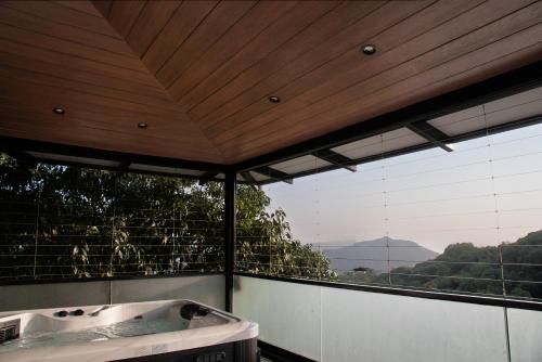 a bath tub in a room with a large window at Brightland Resort & Spa in Mahabaleshwar