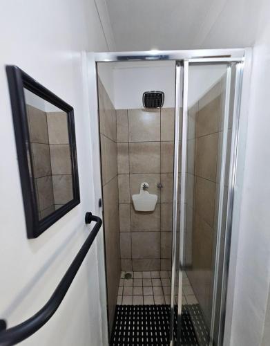 a shower with a glass door in a bathroom at Moo Manor in Kimberley