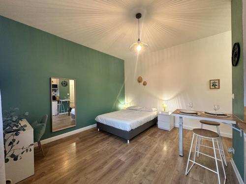 a bedroom with a bed and a desk in it at Le petit Verdier Mosellan - Thionville - 2P in Thionville