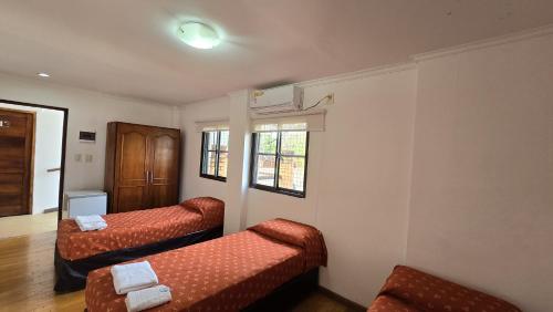a living room with two beds and a window at Tajy Iguazu Hotel in Puerto Iguazú