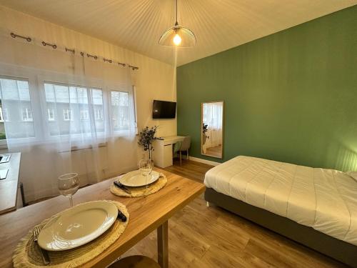 a bedroom with a bed and a table with plates on it at Le petit Verdier Mosellan - Thionville - 2P in Thionville