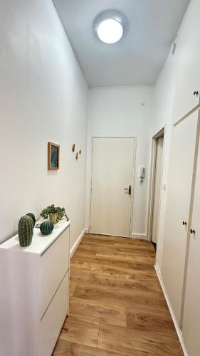 an empty living room with white walls and wood floors at Le petit Verdier Mosellan - Thionville - 2P in Thionville